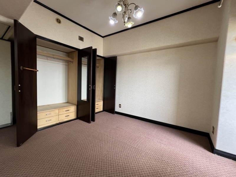 豊富な収納と引き出しが付いた大容量クローゼットを備え、衣類や小物をすっきりと整理できる使い勝手の良い洋室です。