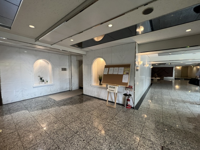 洗練された大理石調の床や上品なニッチが施され、清潔感と高級感が漂う開放的なエントランスホール。
