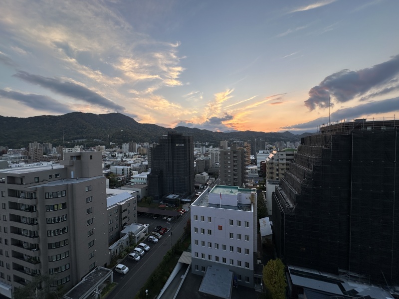 夕景に染まる街並みと山並みを望む、12階からの眺望