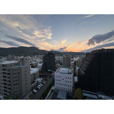 夕景に染まる街並みと山並みを望む、12階からの眺望
