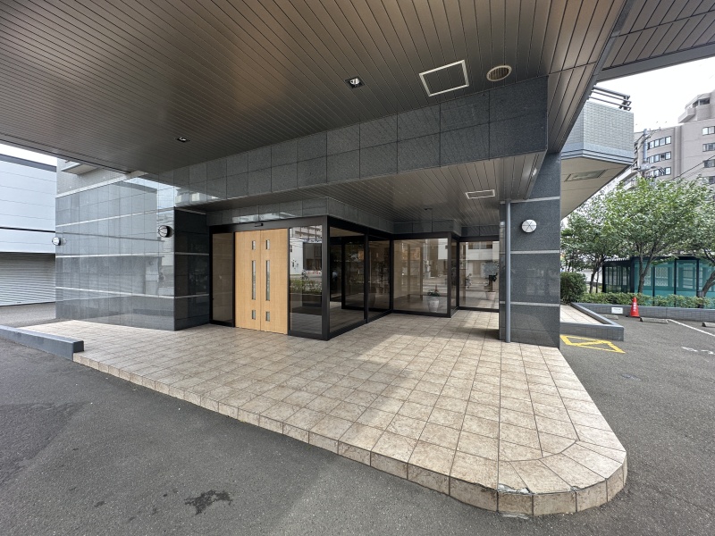 屋根のある車寄せを備えた、落ち着いた佇まいのエントランス