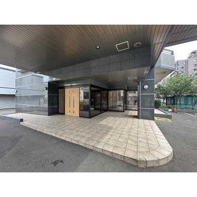 屋根のある車寄せを備えた、落ち着いた佇まいのエントランス