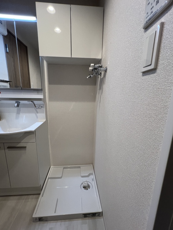 洗濯用品がすぐ手に届く吊戸棚を設置。家事動線に配慮した快適なランドリー環境。