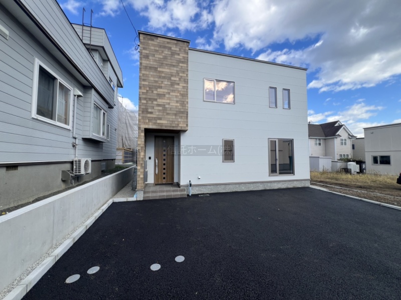 ゆとりある駐車スペースを確保。木目調の玄関がアクセントになった、すっきりとした外観です。