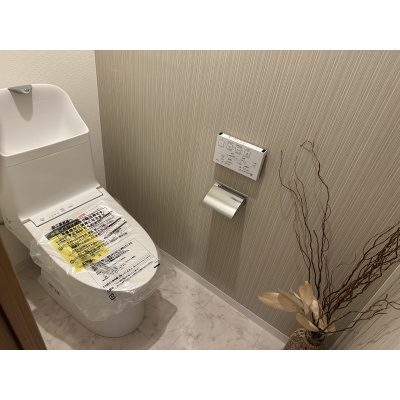 温水洗浄便座付きの清潔感あふれるトイレ。シックなアクセントクロスがおしゃれで落ち着く空間です。