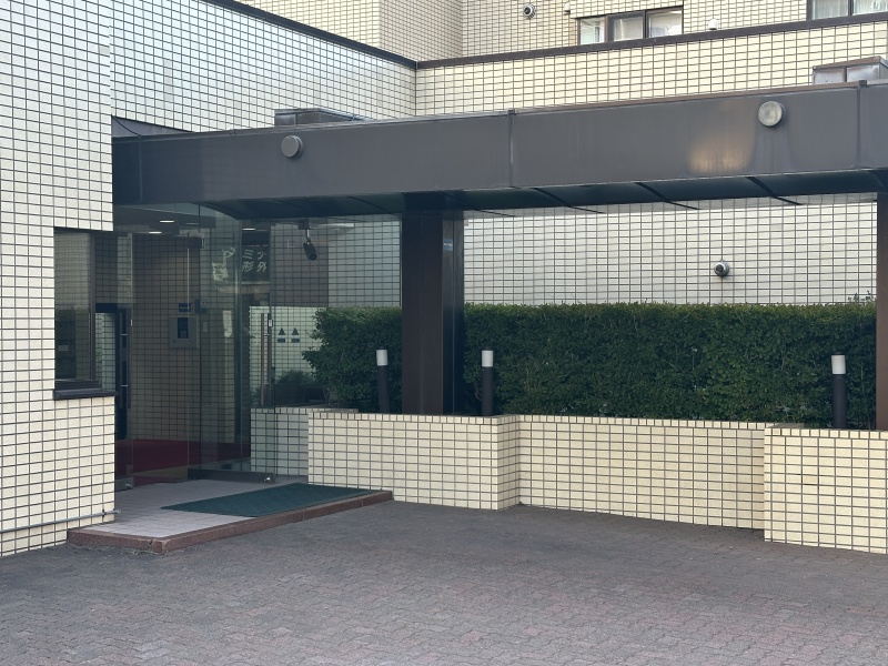 大きな庇付きのアプローチで雨雪でも濡れにくく、植栽の緑が彩る重厚で洗練されたエントランスです。