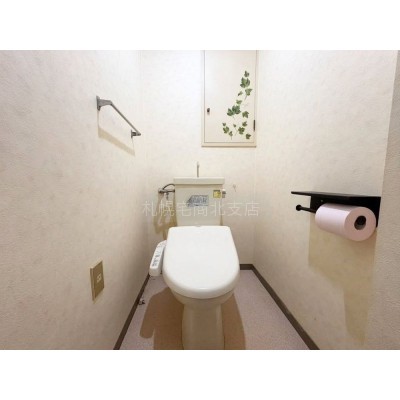 【温水洗浄便座付き】清潔感のあるトイレ空間。棚や壁紙クロス…