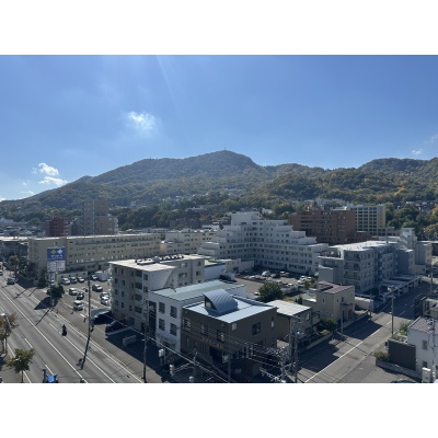 青空のもと青々とした山並みが一望でき、季節の移ろいを感じられる見晴らしのよい眺望です。