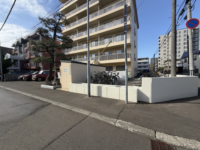通りから見た建物と、整った駐輪スペースです。